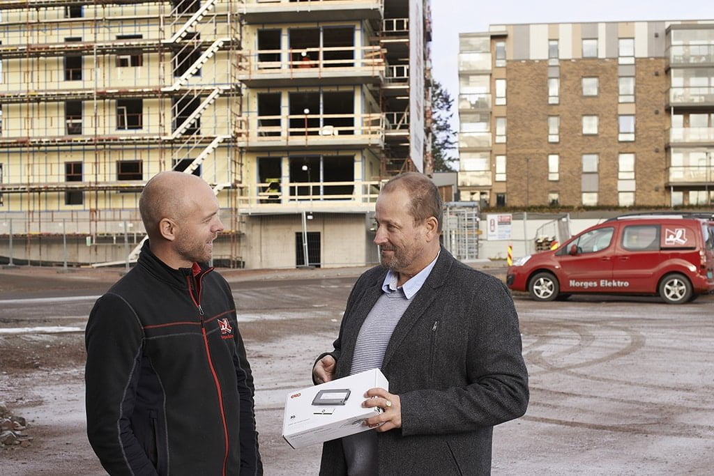 Garo’s sales representative Ingar Skytte presents a stove guard to Henrik Lofstad, Project Manager at Norges Elektro. In the background, construction is underway for 52 apartments at Semshagen, each equipped with a Garo stove guard.